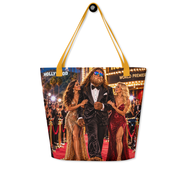 A tote bag with mustard yellow handles and a large printed photo of a red carpet scene featuring Bigfoot in a tuxedo flanked by two women in evening gowns, shown on a plain white background.
