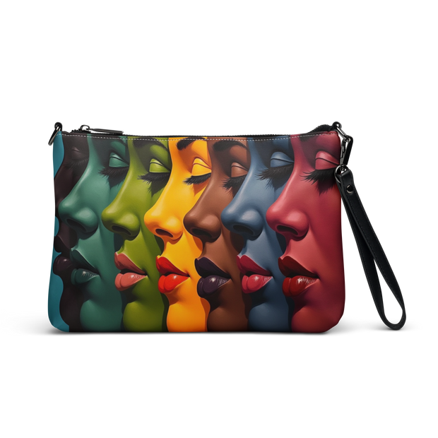 A rectangular wristlet clutch bag with a black wrist strap, featuring a colorful printed design of seven overlapping female faces in profile with closed eyes, each in a different color including teal, green, orange, brown, blue, and red, shown on a plain white background.
